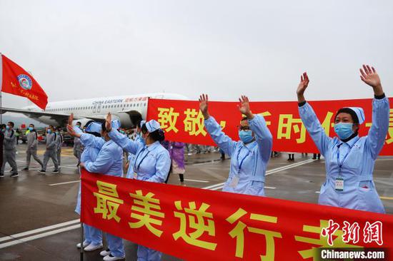 图为前来迎接的医护人员向凯旋而归的白衣战士致意挥手。 刘占昆摄