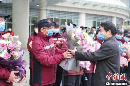 4月1日,江西省人民医院党委书记、院长李秋根向救援队队长张维新献花。江西省人民医院供图
