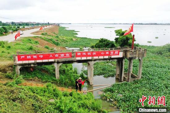 7月9日，在江西省南昌市青山湖区罗家镇红旗联圩，巡堤的村民正在查看河流水情。　刘占昆摄