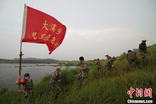 江西上饶市余干县枫富联圩堤坝上,“大溪乡民兵应急排”在巡堤排险。 王成前摄