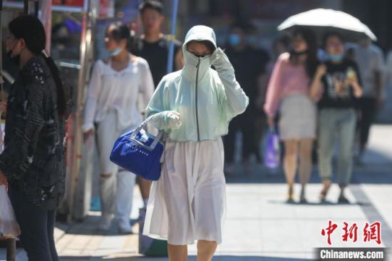 江西南昌“秋老虎”发威,市民全副武装应对高温天气。 刘力鑫 摄