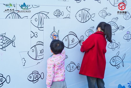 儿童在主题墙前彩绘鱼群