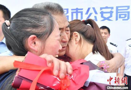 焦爱华、杨风梅夫妇走失34年的女儿终于找到了，一家人在家乡团聚。图为焦爱华双手抱着妻子和女儿。　樊哲平 摄