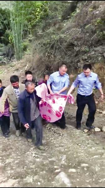 民警和村民将老人抬出山沟