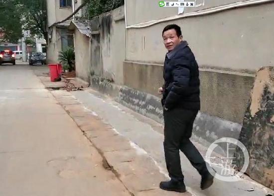 12月18日,江西进贤县城,张玉环出门接人,因为有老旧伤,走路一瘸一拐的。