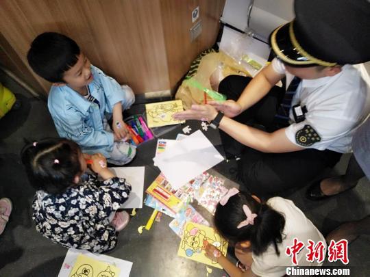 图为乘务人员邀请小旅客们一起做游戏。 李丁 摄