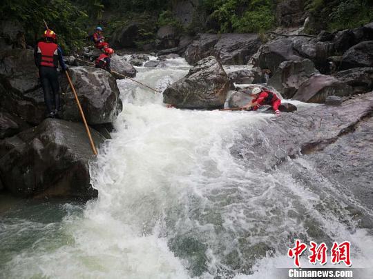 搜救人员在湍急的水流旁进行搜寻。 山福镇供图