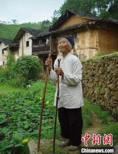 图为池煜华老人站在老屋前。 兴国县委宣传部 摄