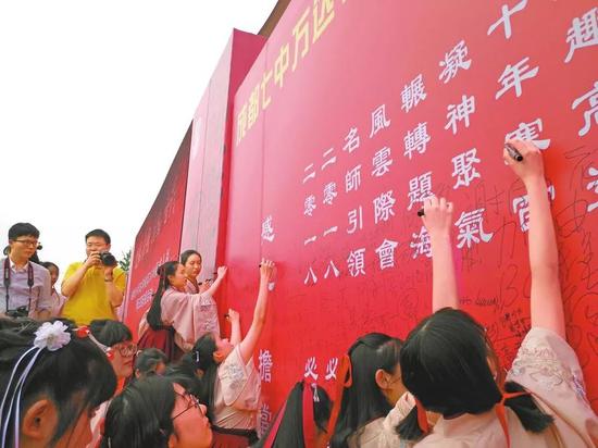 即将参加高考的学生在高考签名墙签名