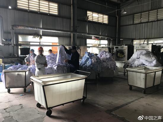 “丰源”洗涤厂内员工在分拣衣物。见习记者于子敬摄