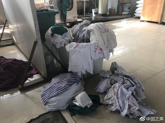 “顺达”洗涤厂内感染区布草堆放在地上。 见习记者于子敬摄