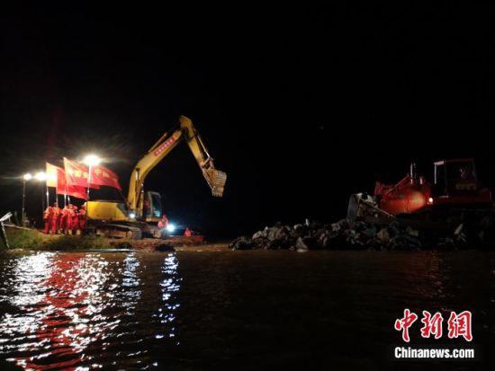13日23时8分,随着推土机驾驶员拉下操纵杆,把最后一车石料推进决口,被洪水撕裂127米决口的问桂道圩完成合龙。 徐迎华 摄