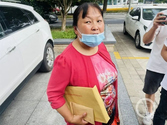 9月9日,江西南昌,劳荣枝案一审宣判后,被害人小木匠的妻子朱大红手中的文件袋里装着判决书。摄影/上游新闻记者 时婷婷