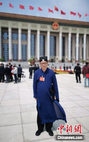 图为5月22日,站在北京人民大会堂前的全国人大代表、中国道教协会副会长、江西龙虎山嗣汉天师府主持张金涛。(受访者供图)