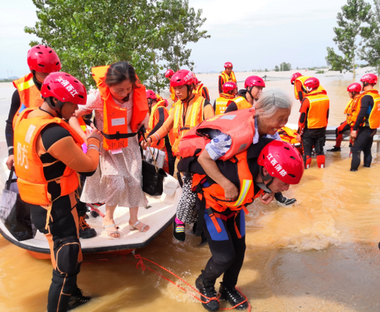 7月11日,江西消防救援总队集结的6个支队队员在鄱阳县昌洲乡昌洲大桥桥头帮助群众转移。摄影∣江西日报记者陈化先