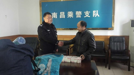 图为乘警归还聂先生遗失的巨款。