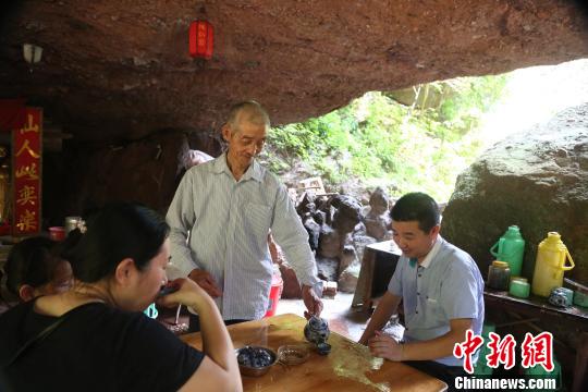 30日,和往日一样,一头白发的周文荣为游客冲泡茶水。 姜涛 摄