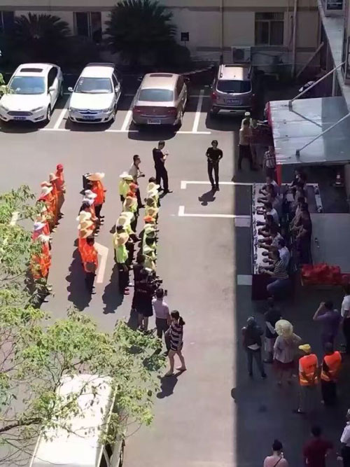8月11日，江西南昌市青山湖区举行慰问环卫工人的爱心活动，图片中环卫工人站在烈日下，等待着坐在旁边阴凉处的领导们发放慰问品。微博图