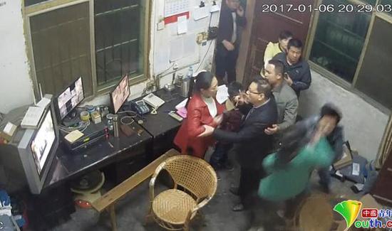 绿衣服女子为教师，正在被学生家长殴打。监控视频截图。