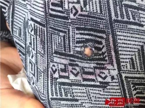 邬乃从的家属拿出他事发时穿的内衣,上面留下一个子弹穿过的孔。 图/北京时间尹志艳