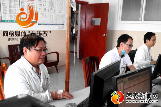 网上传播的黄绍明(左一)“打点滴坐诊”的图片。