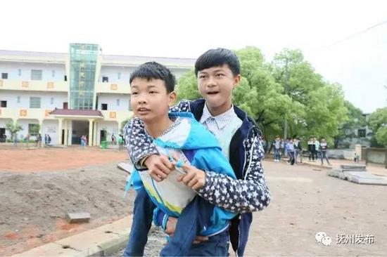 ▲黄迅哲背着徐志鹏在校园里散步