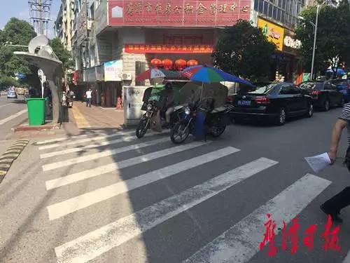 二中门口“摩的”司机在等客。