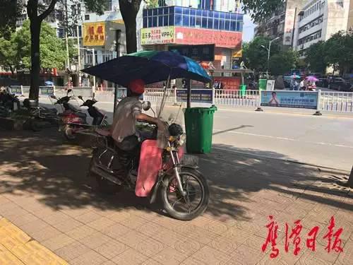 “摩的”司机停在人行道中间待客。