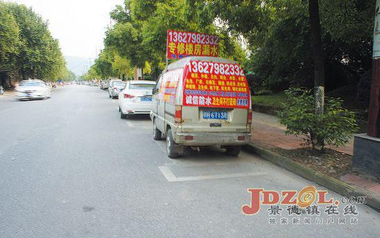 一辆灰色微型车上贴满房屋漏水修补广告