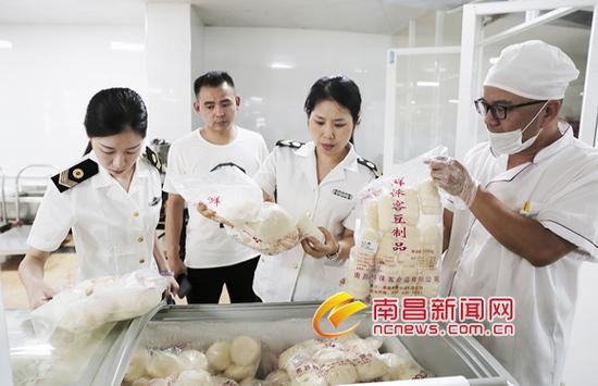 执法人员对南昌师范附属实验小学(玉泉岛校区)食堂的食品生产厂家、生产日期进行检查