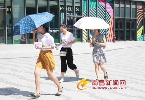 图为10月10日我市烈日当空最高气温达到了33.8℃ 市民撑伞遮阳