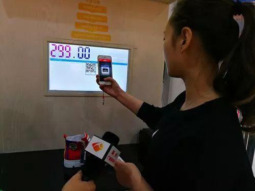 △进店消费的顾客正在扫码付款。