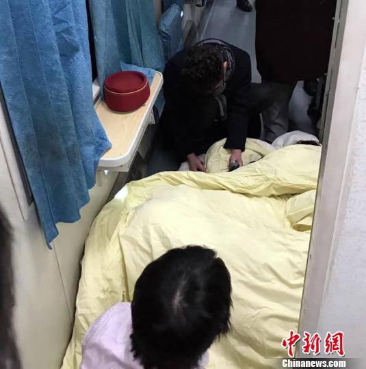 图为列车工作人员和热心旅客在车厢里搭建临时“产房”,救治产妇和婴儿 李江 摄