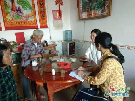 图为邓小梅(上图右边穿黄色花衬衫者)走访贫困户