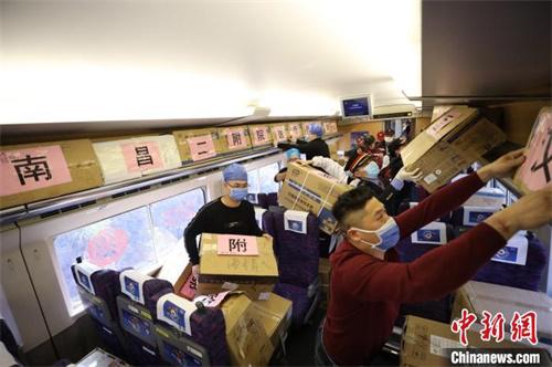 2月13日，D3226次列车抵达湖北武汉，列车工作人员协助江西省援助湖北医疗队搬运医疗物资。　丁波 摄