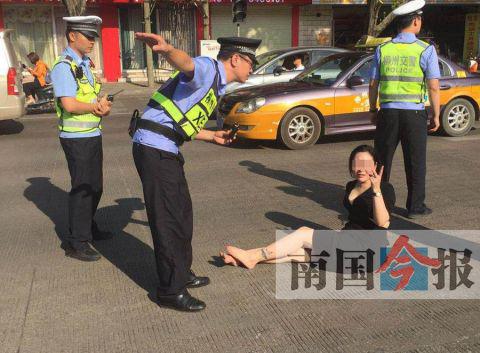 图为醉酒女子坐在马路中间，任凭民警反复劝告也不肯离去。 谢志刚 摄