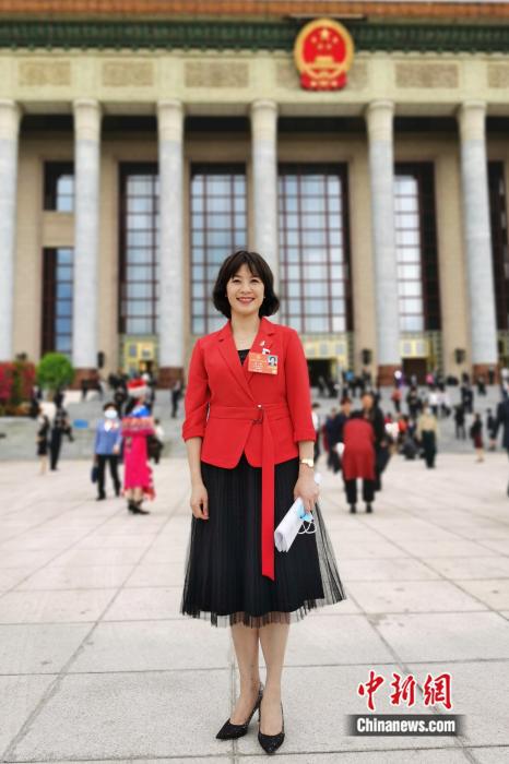 图为全国人大代表、江西省律师协会副会长、江西省新的社会阶层人士联谊会副会长冯帆在北京人民大会堂前。受访者供图