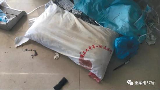 11月29日,顺达洗涤服务中心内,一个带血的枕头被工人扔在地上的垃圾堆里等待洗涤,旁边还堆放了医生手术帽和输液管等医疗废物。新京报记者尹亚飞摄