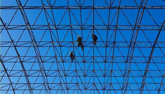 ▵工人在安装航站楼二楼屋顶的钢网架（资料图）