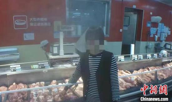 女子指认超市内盗取猪肉现场。自贡高新警方 供图