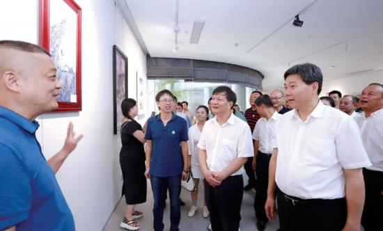 7月17日,在三宝蓬艺术聚落,陈兴超、钟志生一行参观“景漂之家”成员画作。 (本报记者黄原珂摄)