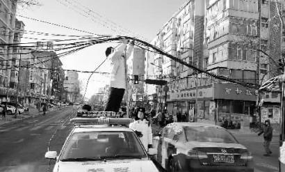 民警站在警车上托举缆线