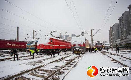 图为铁路工作人员正在清理轨道积雪。(图片来源于网络)