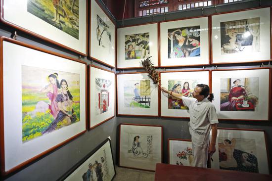 一进状元阁,任静就如平日一样,拿起鸡毛掸子,为他的每一幅作品拂去尘灰。