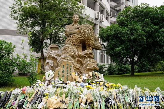 5月22日,西南大学袁隆平雕塑前摆放着师生们敬献的鲜花。新华社发(秦廷富 摄)