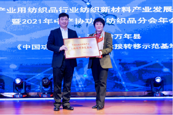 中国产业用纺织品行业协会会长李桂梅为万年县授《中国功能纺织品产业承接转移示范基地》牌匾。