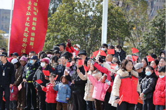 图为：江西省九江市彭泽县迎来了一场专属于“非遗”的狂欢盛宴，当地新春长江文化民俗踩街活动现场，市民挥舞着五星红旗观看。（彭琴&nbsp;摄）