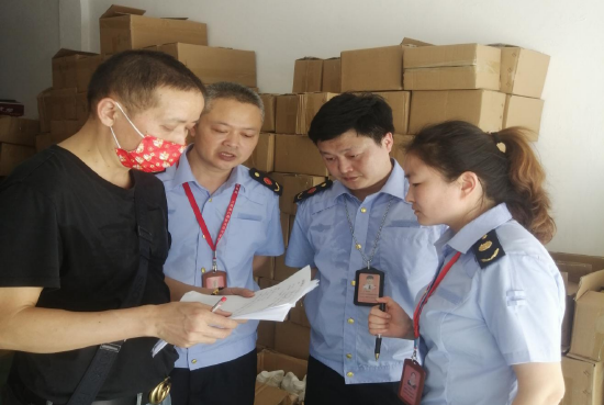 九江市市场监管局执法人员现场清点查封扣押物品