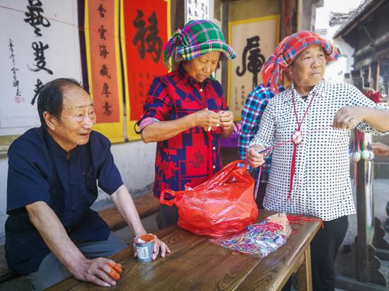 村里的老人为游客奉上端午传统习俗