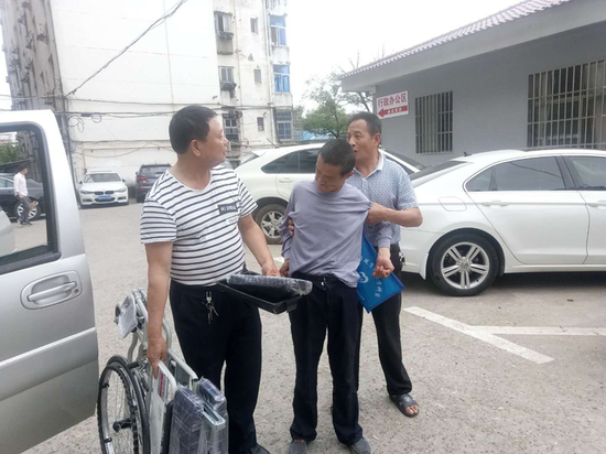 杨惠林亲自把轮椅送到熊汗华家人手中